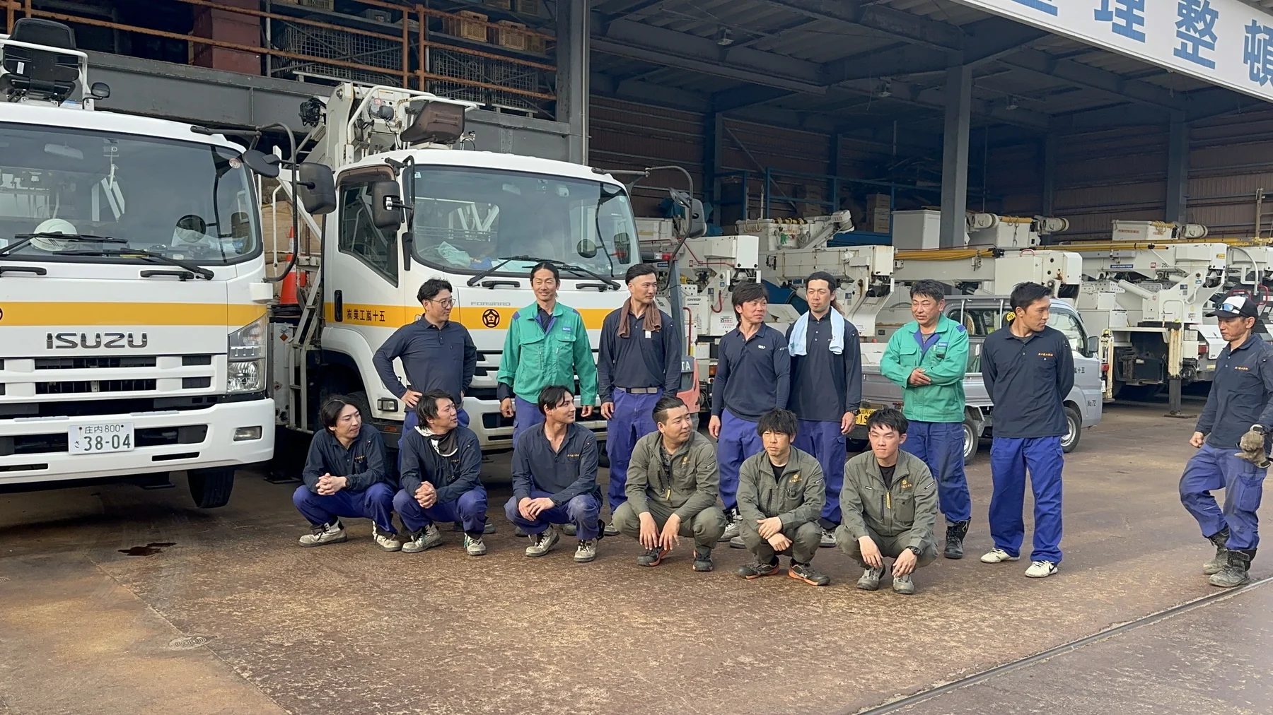作業車の前で会話する社員たち