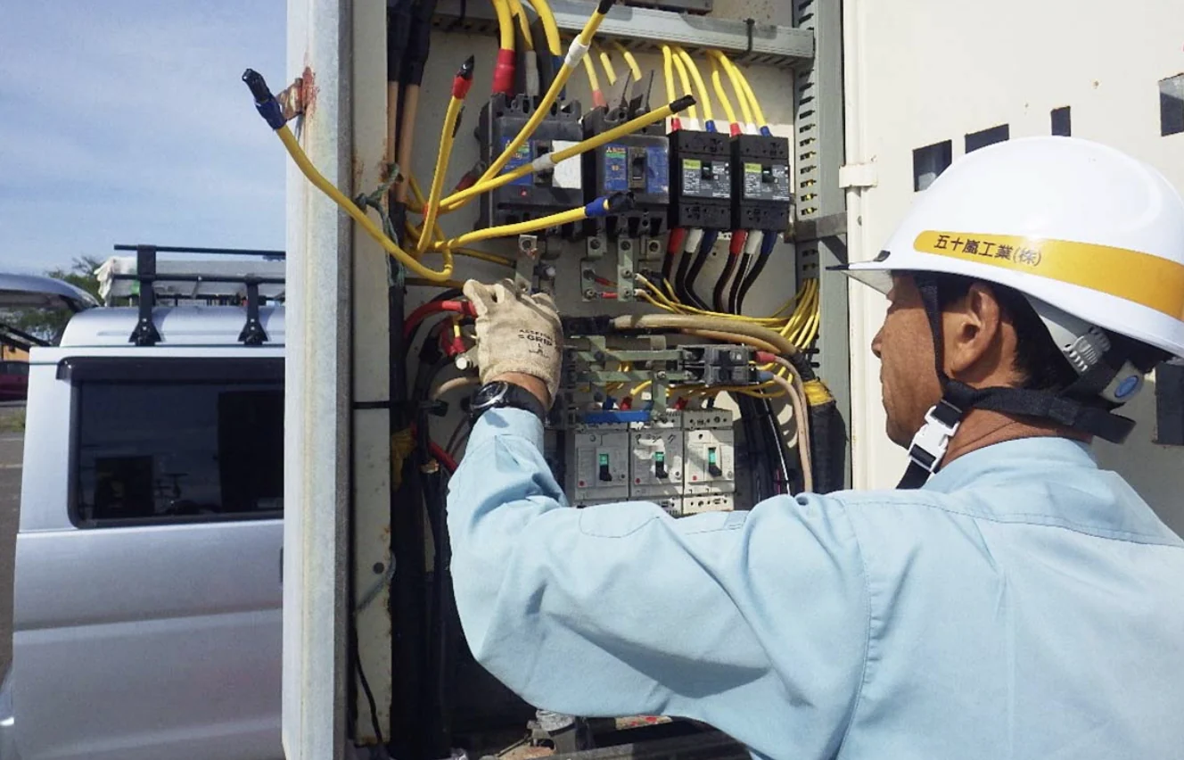 電気設備の前で作業する社員