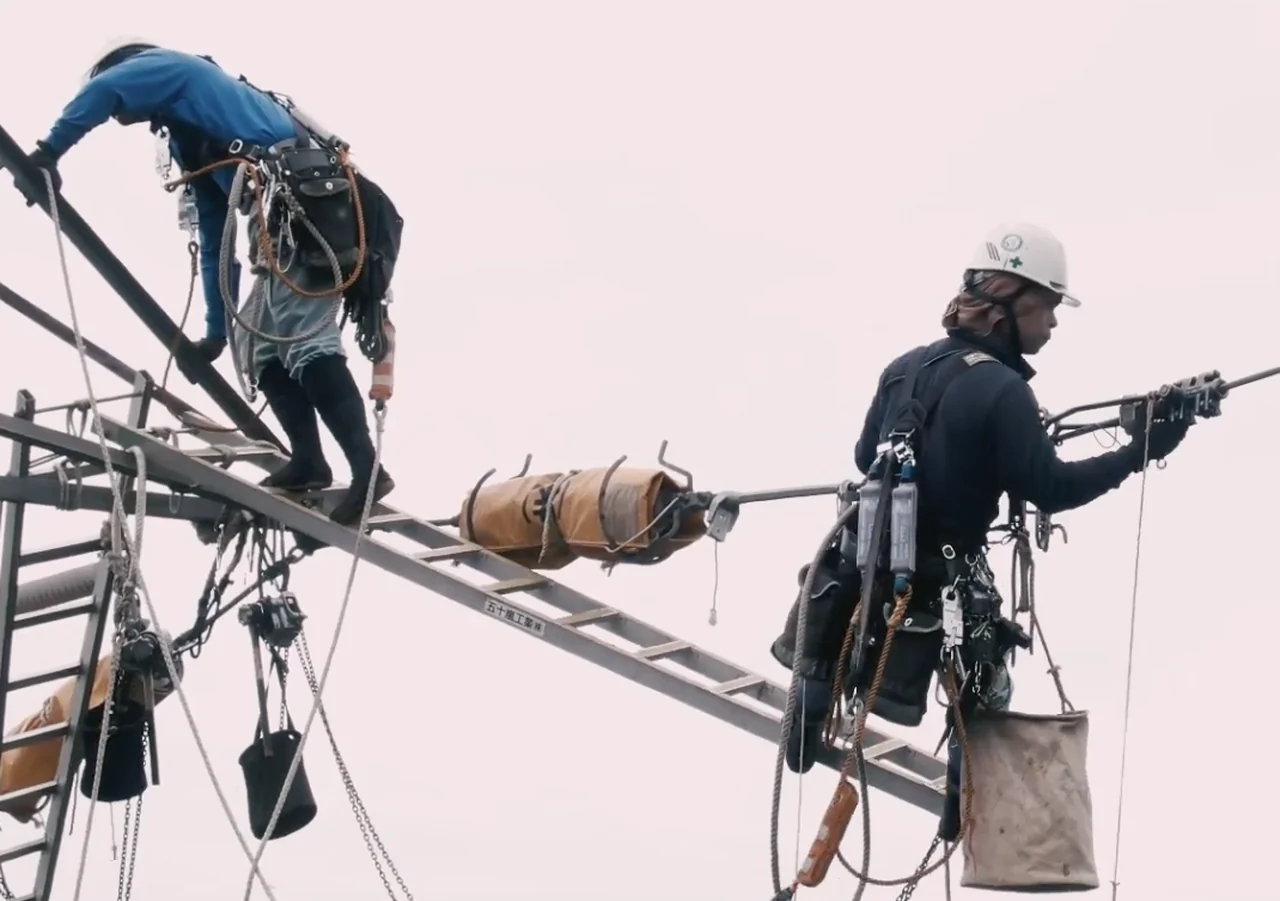 鉄塔上で作業する送電の現場